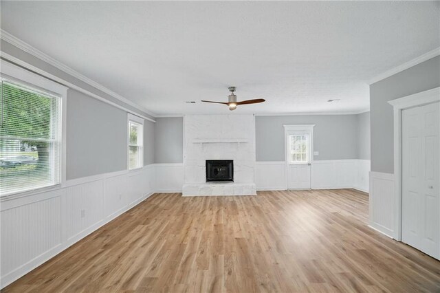 46 Forkwood Cir, Hiram, GA 30141 - unfurnished living room with a large fireplace, a ceiling fan, crown molding, and wainscoting