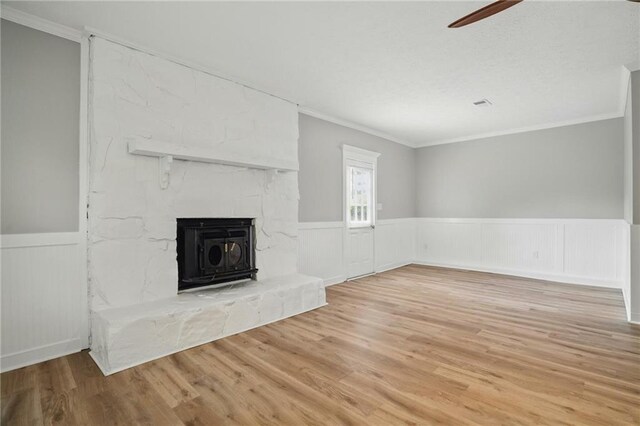 46 Forkwood Cir, Hiram, GA 30141 - unfurnished living room featuring wood finished floors, ornamental molding, a wainscoted wall, a fireplace, and a ceiling fan