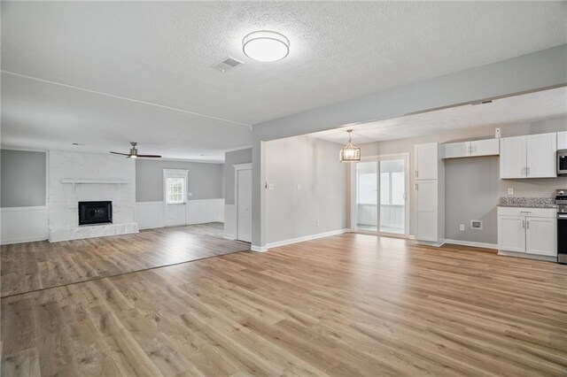 46 Forkwood Cir, Hiram, GA 30141 - unfurnished living room with a fireplace, a textured ceiling, light wood-style floors, and visible vents