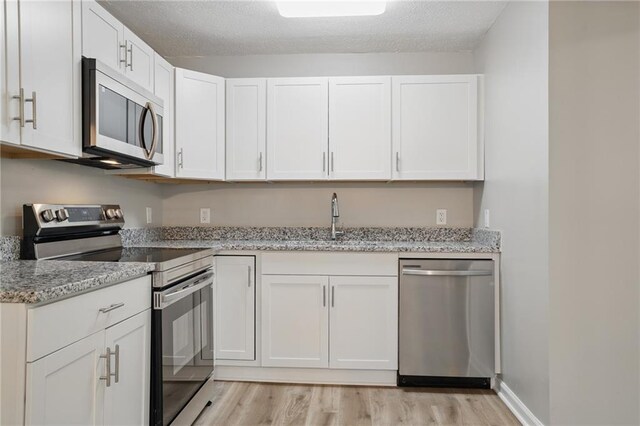 46 Forkwood Cir, Hiram, GA 30141 - kitchen with light wood finished floors, a sink, white cabinets, and stainless steel appliances