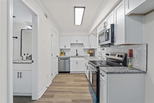 4701 Flat Shoals Rd Unit 56E, Union City, GA 30291 - kitchen with decorative backsplash, stainless steel appliances, white cabinetry, and light hardwood / wood-style flooring