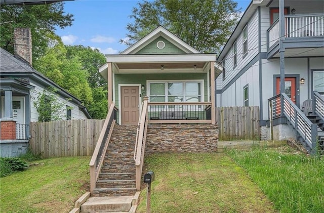 view of front of house featuring covered porch and a front yard