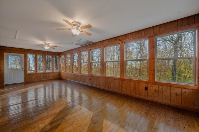 unfurnished sunroom featuring ceiling fan and a wealth of natural light