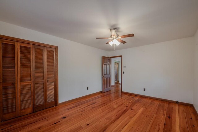 unfurnished bedroom featuring ceiling fan, light wood-type flooring, and a closet