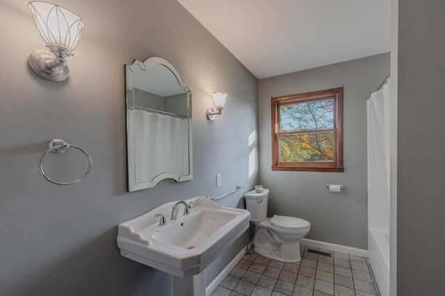 bathroom with tile patterned floors, curtained shower, sink, and toilet