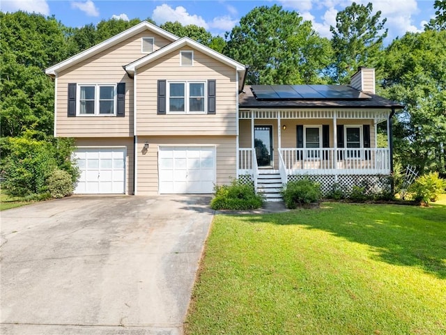 443 Rhett Dr, Loganville, GA 30052 - tri-level home with covered porch, a chimney, a front lawn, an attached garage, and roof mounted solar panels