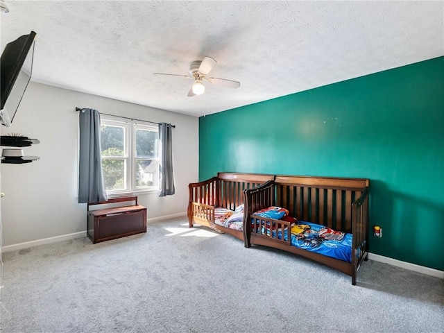 443 Rhett Dr, Loganville, GA 30052 - carpeted bedroom with a textured ceiling, a ceiling fan, and a nursery area