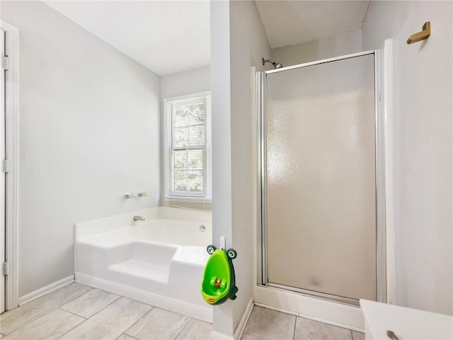 443 Rhett Dr, Loganville, GA 30052 - bathroom featuring a stall shower, a bath, and tile patterned floors
