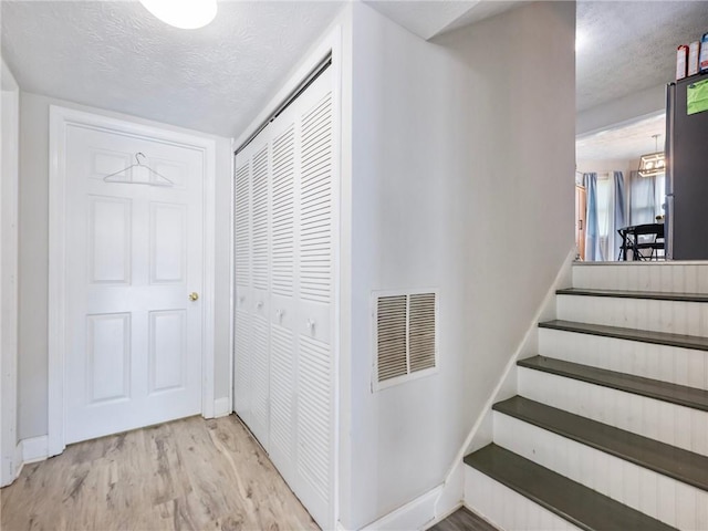 443 Rhett Dr, Loganville, GA 30052 - staircase featuring a textured ceiling and wood finished floors