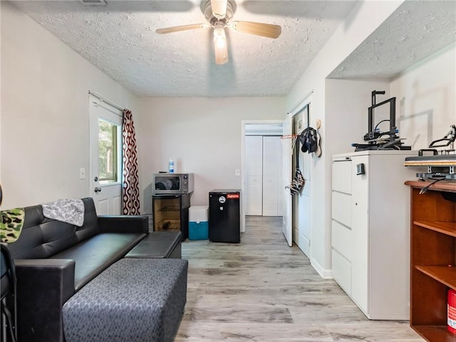 443 Rhett Dr, Loganville, GA 30052 - living room with a textured ceiling, light wood-style flooring, and a ceiling fan