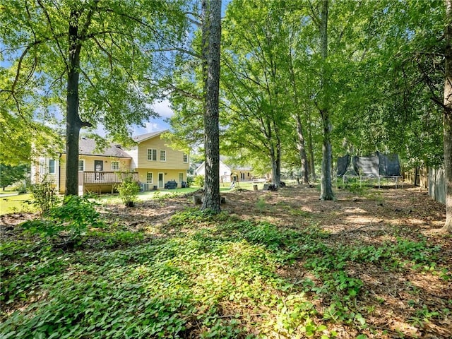 443 Rhett Dr, Loganville, GA 30052 - view of yard featuring a trampoline and a wooden deck