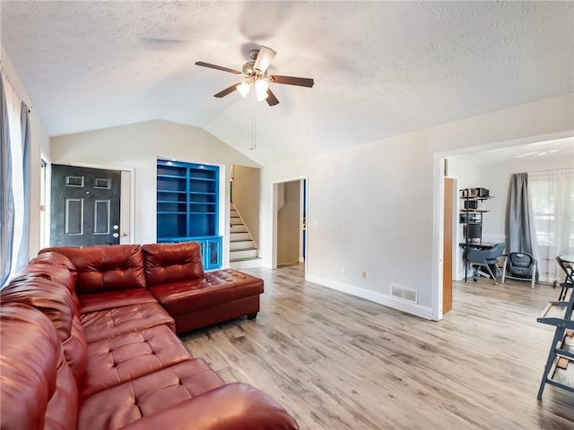 443 Rhett Dr, Loganville, GA 30052 - living room featuring a ceiling fan, light wood-type flooring, a textured ceiling, stairway, and lofted ceiling