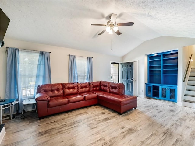 443 Rhett Dr, Loganville, GA 30052 - living room with wood finished floors, lofted ceiling, a ceiling fan, healthy amount of natural light, and a textured ceiling