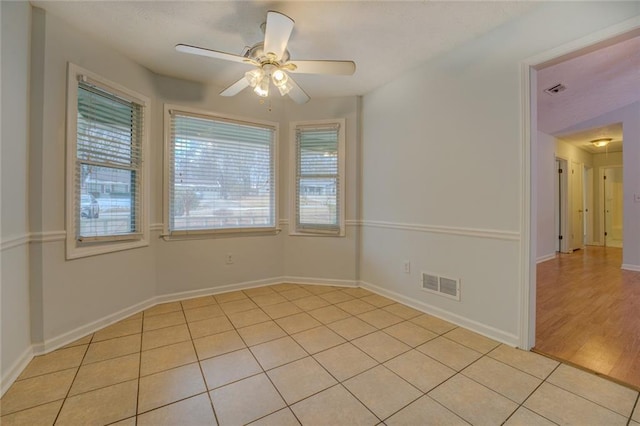 tiled empty room with ceiling fan