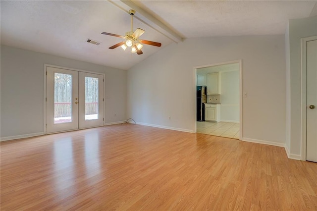 empty room featuring lofted ceiling with beams, french doors, ceiling fan, and light hardwood / wood-style floors