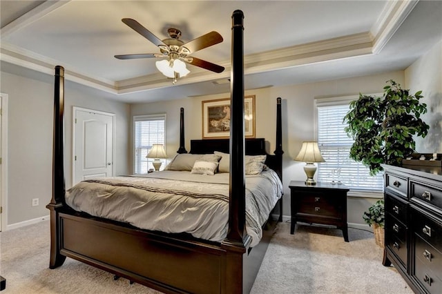 carpeted bedroom featuring ceiling fan, a raised ceiling, and crown molding