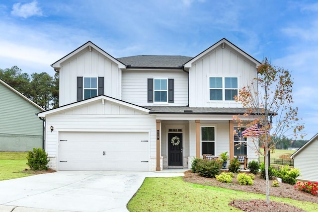 view of front of property with a garage, a front lawn, and covered porch