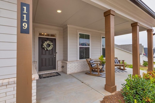 view of exterior entry featuring covered porch