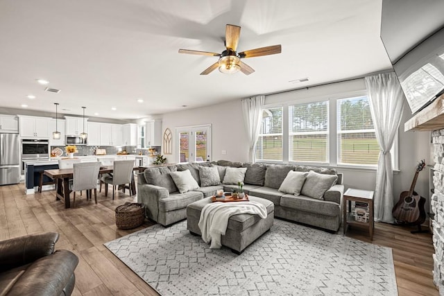 living room featuring light wood-type flooring and ceiling fan