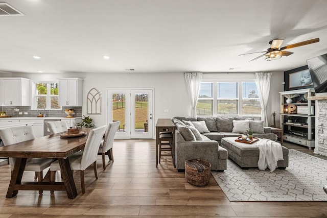 living room with hardwood / wood-style flooring, ceiling fan, and a healthy amount of sunlight