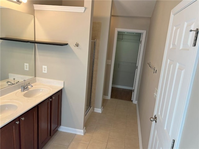 bathroom with tile patterned flooring, vanity, and a shower with shower door