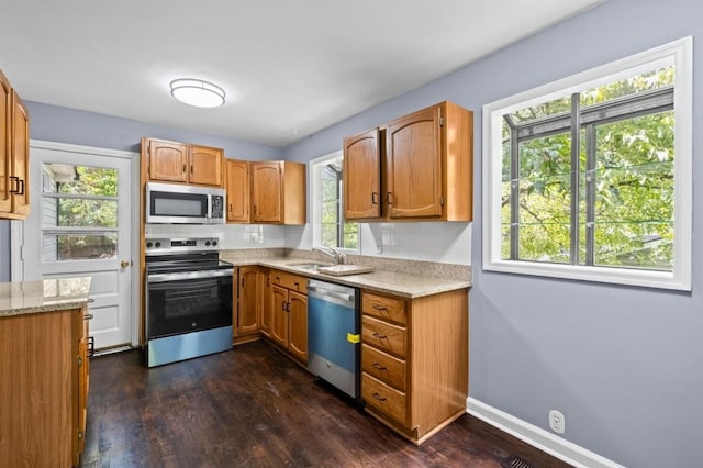 881 Mclinden Ave SE, Smyrna, GA 30080 - kitchen with appliances with stainless steel finishes, dark wood finished floors, brown cabinetry, and light stone counters