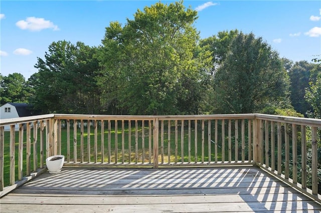 wooden deck featuring a lawn