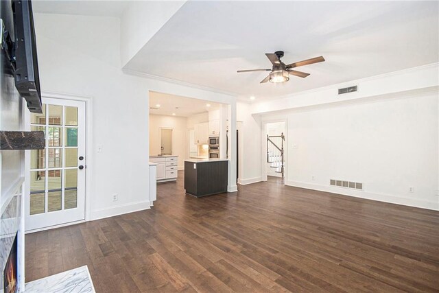 unfurnished living room with ceiling fan, stairway, dark wood-style floors, baseboards, and recessed lighting