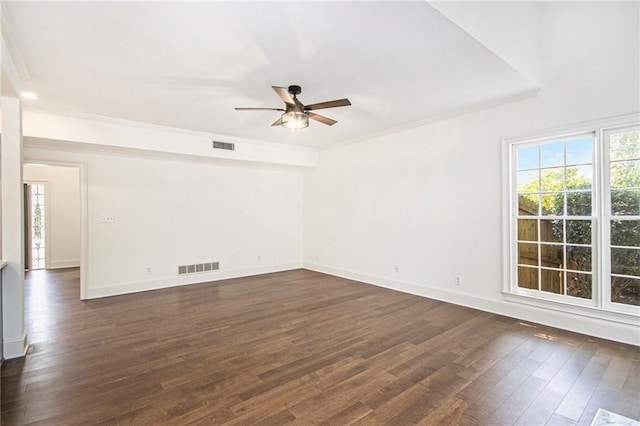 empty room with ceiling fan, dark wood finished floors, ornamental molding, and baseboards