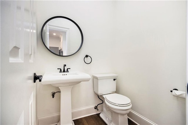 bathroom featuring baseboards, toilet, and wood finished floors