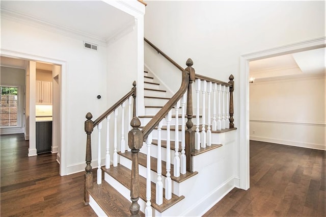 stairs featuring wood finished floors, crown molding, and baseboards