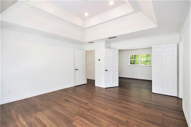 unfurnished bedroom featuring a raised ceiling, dark wood-style floors, baseboards, and recessed lighting