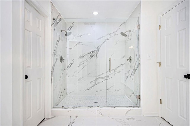 bathroom with a marble finish shower, marble finish flooring, and recessed lighting