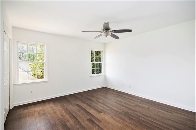 empty room featuring dark wood-style flooring, ceiling fan, and baseboards