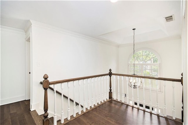 staircase featuring wood finished floors, a chandelier, crown molding, baseboards, and a tray ceiling
