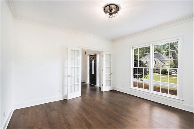 spare room with french doors, ornamental molding, dark wood finished floors, and baseboards