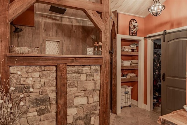 wine cellar featuring ornamental molding, vaulted ceiling, a barn door, and wood ceiling