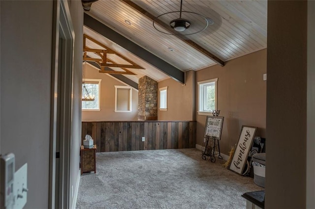 interior space featuring lofted ceiling with beams, wooden ceiling, a wealth of natural light, and wooden walls