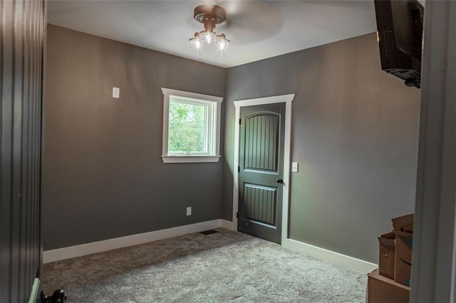 spare room featuring ceiling fan and carpet