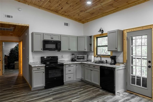 kitchen featuring dark hardwood / wood-style flooring, black appliances, and gray cabinetry