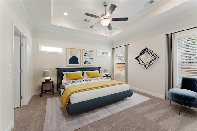 bedroom with crown molding, visible vents, a tray ceiling, and carpet flooring