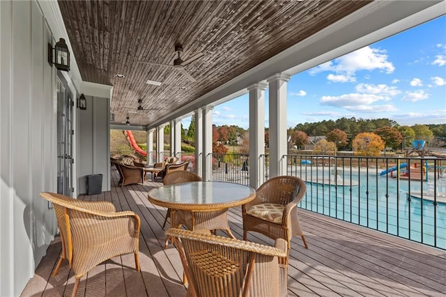 deck featuring a ceiling fan and a community pool