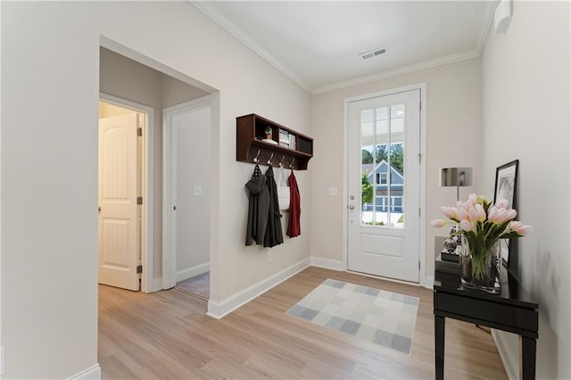 doorway to outside featuring crown molding, baseboards, visible vents, and light wood-style floors