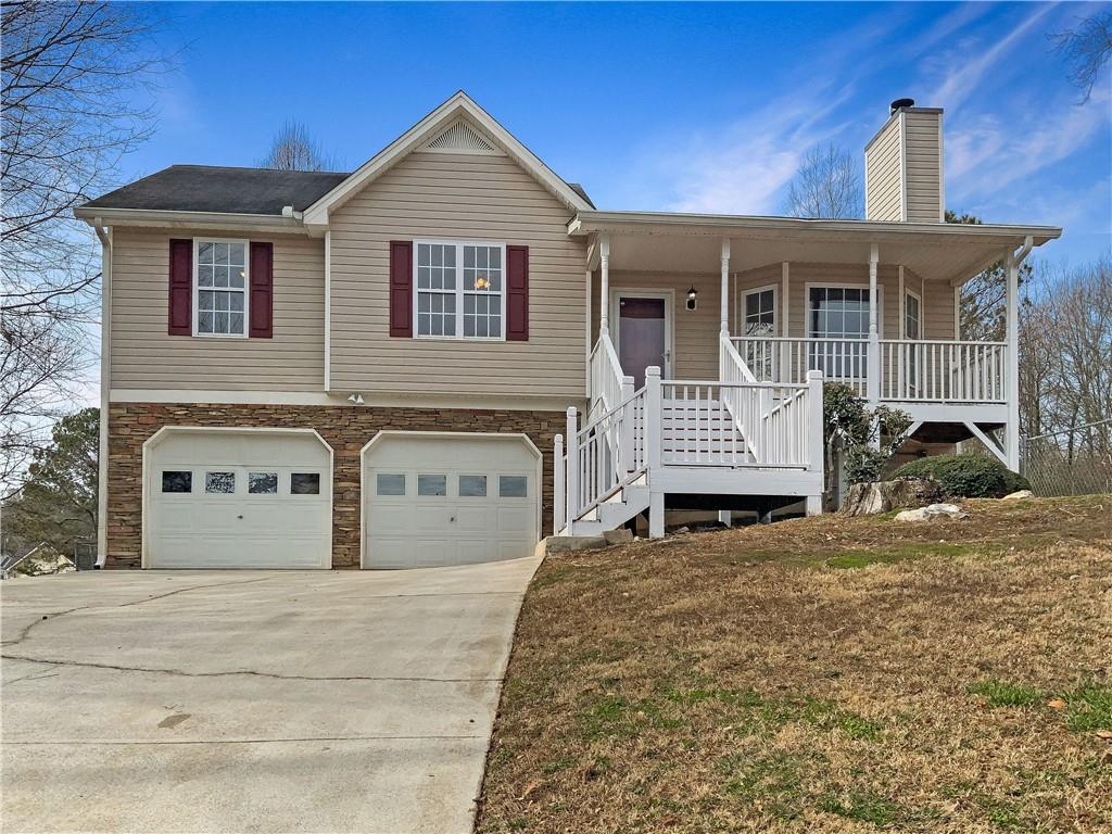 view of front facade featuring a porch, a garage, and a front yard