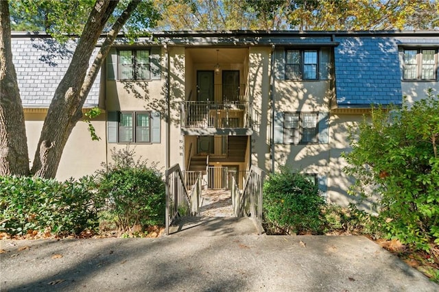 multi unit property with a balcony and stucco siding