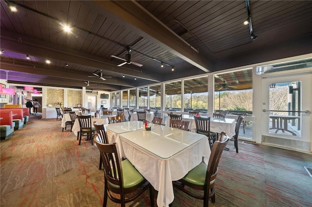 dining area with a ceiling fan, beam ceiling, rail lighting, and a sunroom