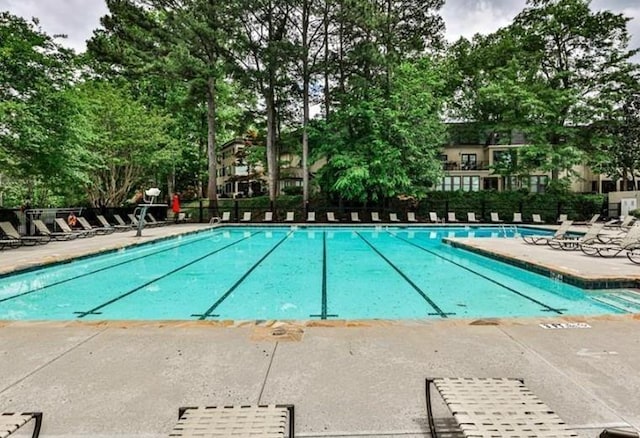 pool with a patio area and fence