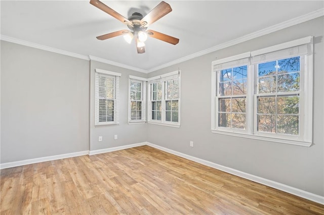 empty room featuring light wood-style floors, crown molding, and baseboards