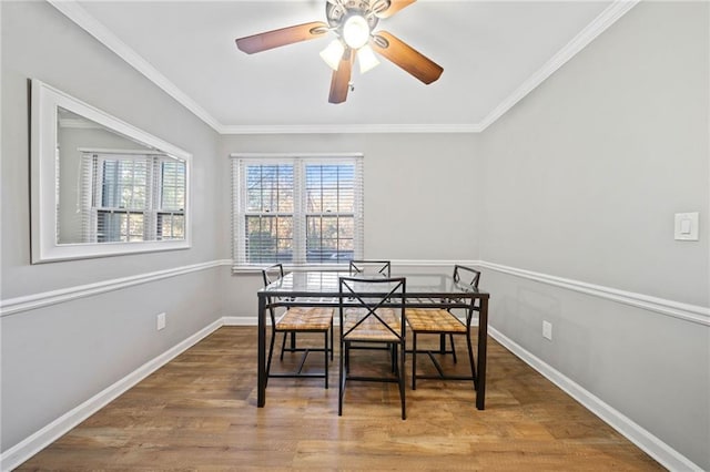 dining room with a ceiling fan, baseboards, ornamental molding, and wood finished floors