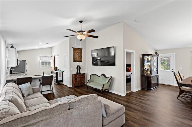 living room featuring ceiling fan, baseboards, vaulted ceiling, and dark wood finished floors